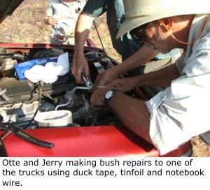 Dan Otte and Jerry Graf making bush repairs to one of the trucks using duck tape, tinfoil and notebook wire.