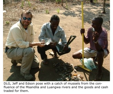 Daniel Graf, Jeff and Edson pose with a catch of mussels from the confluence of the Msandila and Luangwa rivers and the goods and cash traded for them.